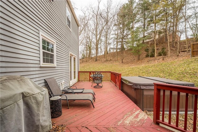 wooden terrace with area for grilling, a yard, and a covered hot tub