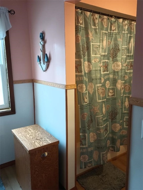 bathroom featuring wood-type flooring and walk in shower