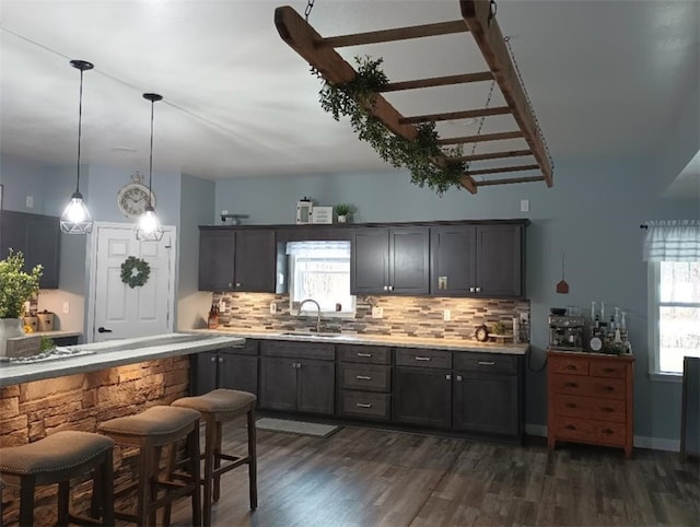 kitchen with sink, hanging light fixtures, dark hardwood / wood-style floors, a wealth of natural light, and backsplash