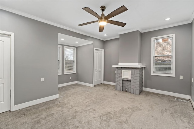 unfurnished living room with a wealth of natural light, a brick fireplace, light carpet, and crown molding