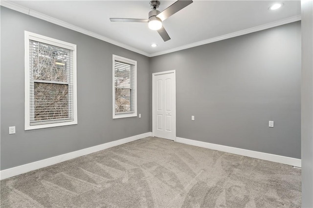 carpeted empty room featuring crown molding and ceiling fan