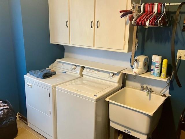 washroom featuring sink, cabinets, and washing machine and clothes dryer