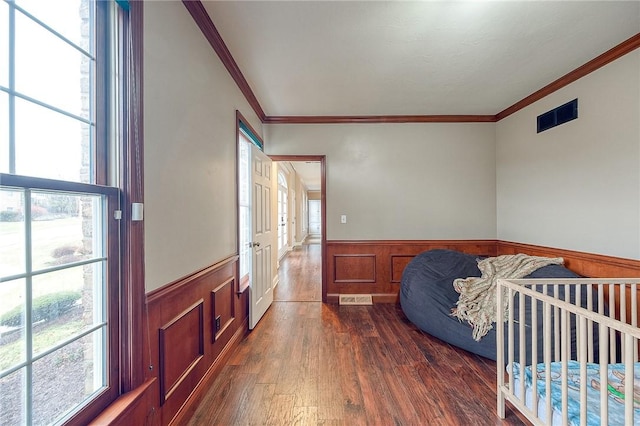 bedroom featuring multiple windows, crown molding, and dark hardwood / wood-style flooring