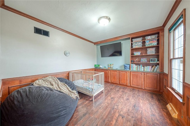 bedroom with dark hardwood / wood-style flooring and ornamental molding