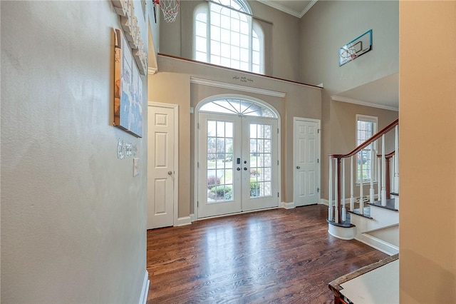 foyer featuring dark wood-type flooring, a healthy amount of sunlight, and ornamental molding