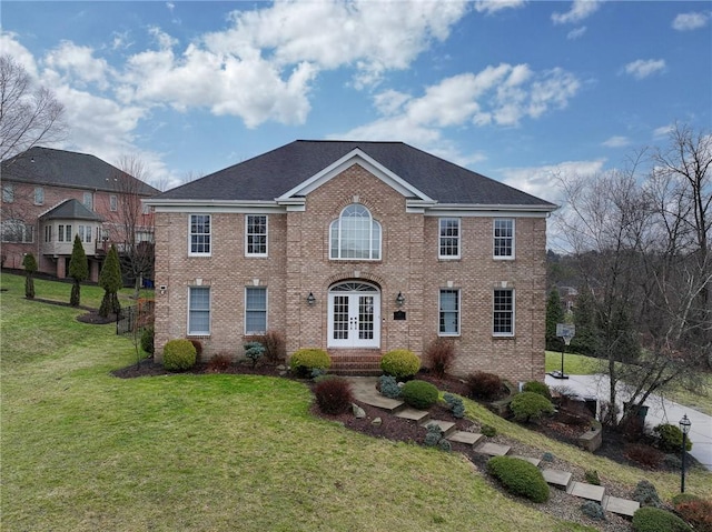 colonial inspired home with a front yard and french doors