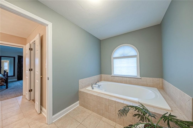 bathroom with tile patterned flooring and a relaxing tiled tub