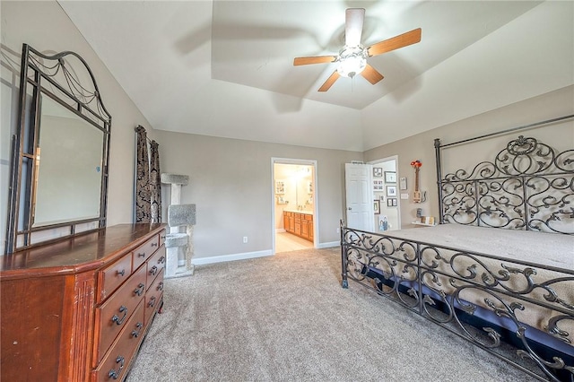 bedroom with connected bathroom, vaulted ceiling, and light carpet