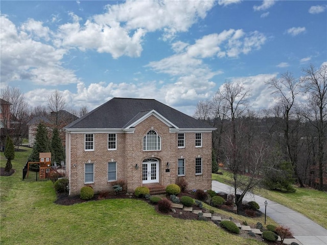 colonial home featuring french doors, a playground, and a front lawn