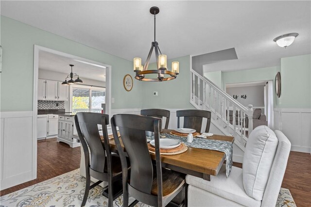 dining area featuring dark hardwood / wood-style flooring and a chandelier