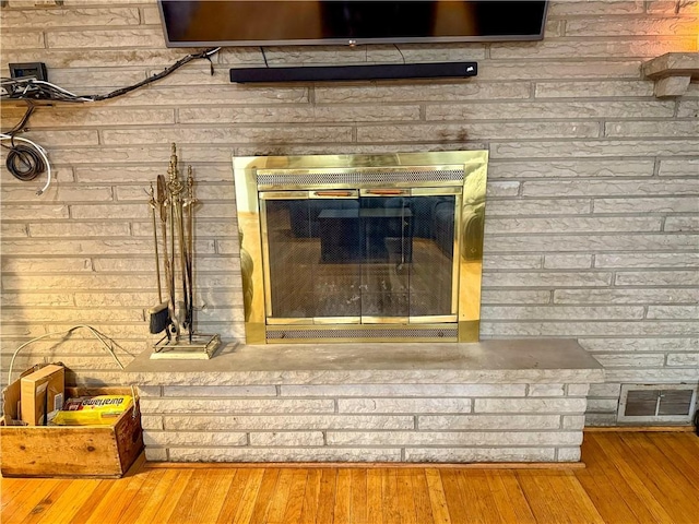 details featuring a brick fireplace and hardwood / wood-style flooring