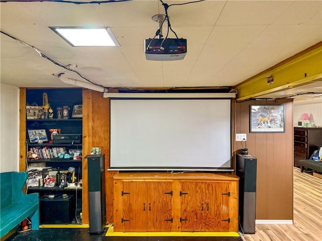 cinema with light hardwood / wood-style floors and wood walls