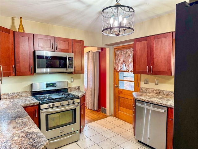 kitchen with pendant lighting, stone counters, stainless steel appliances, light tile patterned flooring, and a chandelier