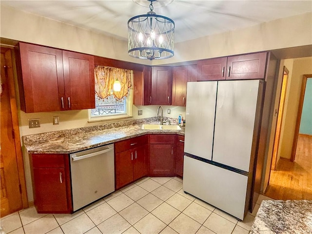 kitchen with sink, decorative light fixtures, refrigerator, dishwasher, and a notable chandelier