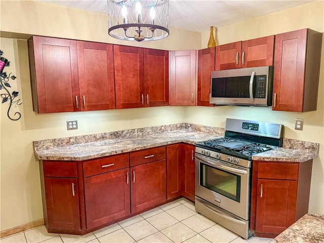 kitchen with light stone counters, light tile patterned floors, stainless steel appliances, and an inviting chandelier