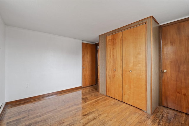 unfurnished bedroom featuring light hardwood / wood-style floors and a closet