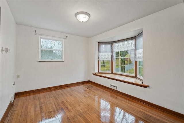 spare room with hardwood / wood-style flooring and a wealth of natural light