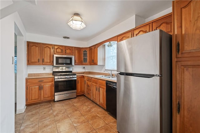 kitchen with appliances with stainless steel finishes, sink, and light tile patterned floors