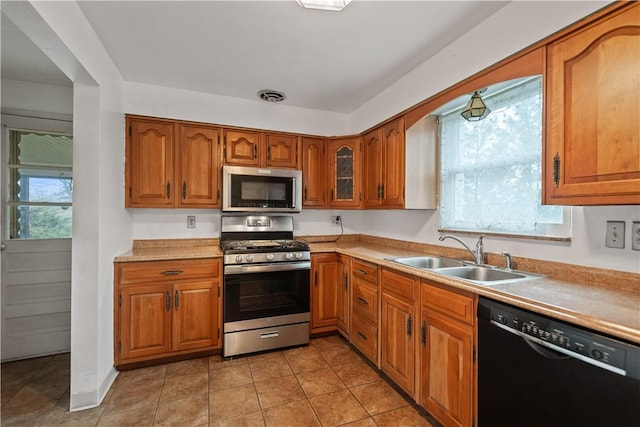 kitchen featuring light tile patterned flooring, stainless steel appliances, and sink