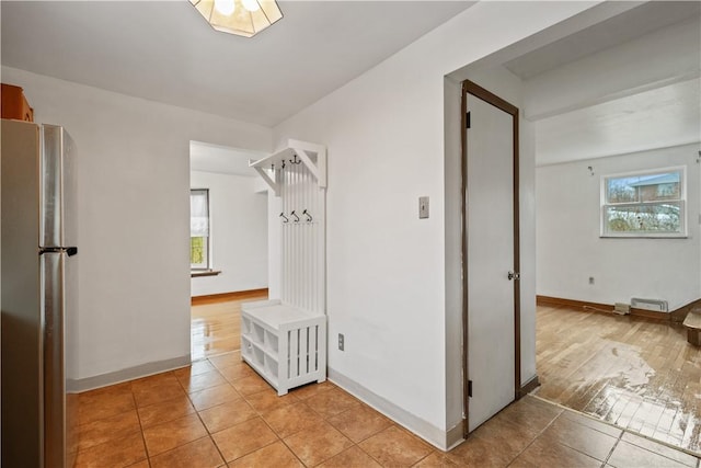 hallway featuring plenty of natural light and light tile patterned floors