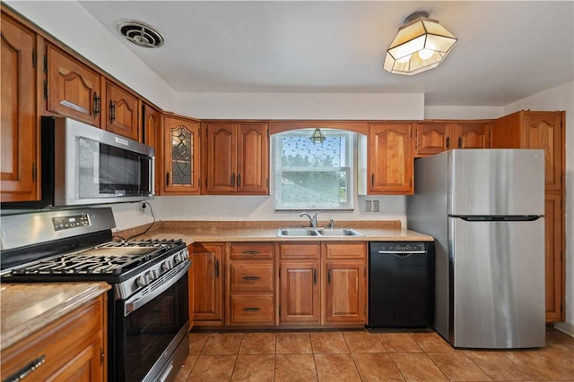 kitchen featuring stainless steel appliances, sink, and light tile patterned floors