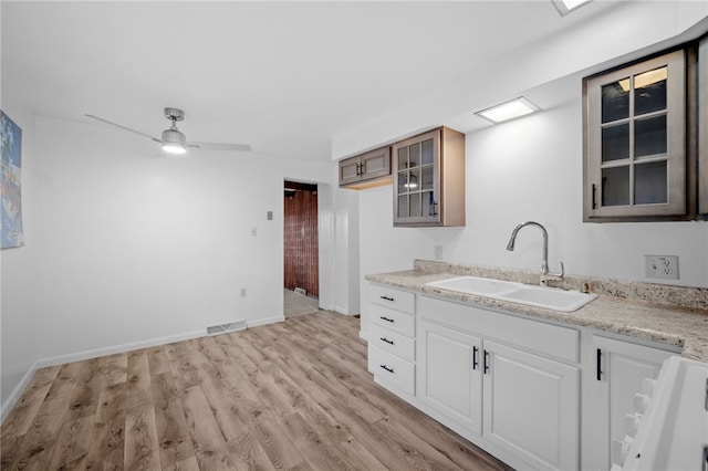 kitchen featuring sink, white cabinetry, range, light hardwood / wood-style flooring, and ceiling fan