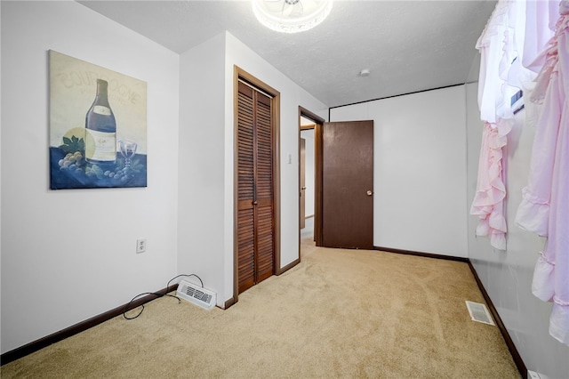 carpeted bedroom featuring a textured ceiling and a closet