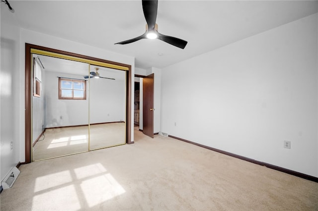 unfurnished bedroom with light colored carpet, a closet, and ceiling fan