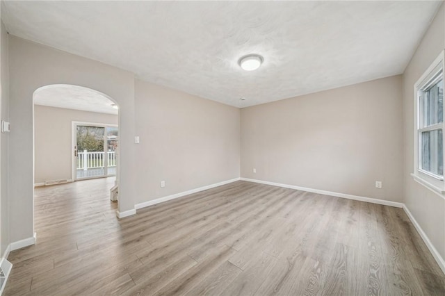 unfurnished room with light hardwood / wood-style floors and a textured ceiling