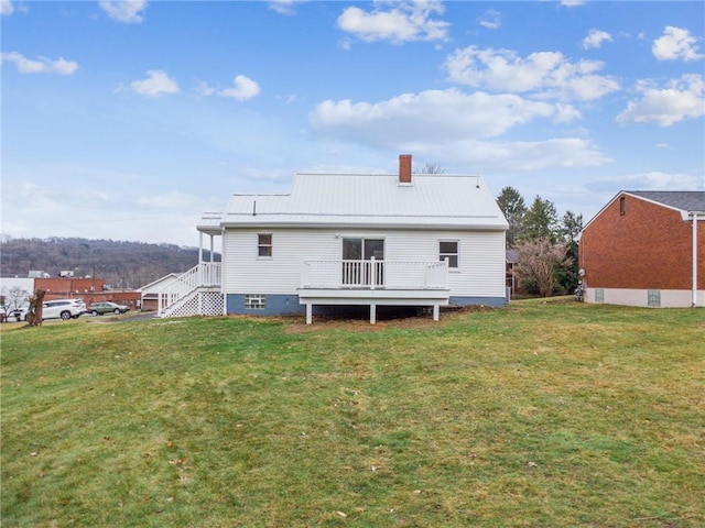 rear view of house featuring a yard and a deck