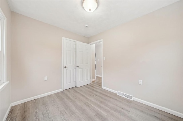 unfurnished bedroom featuring a closet and light wood-type flooring