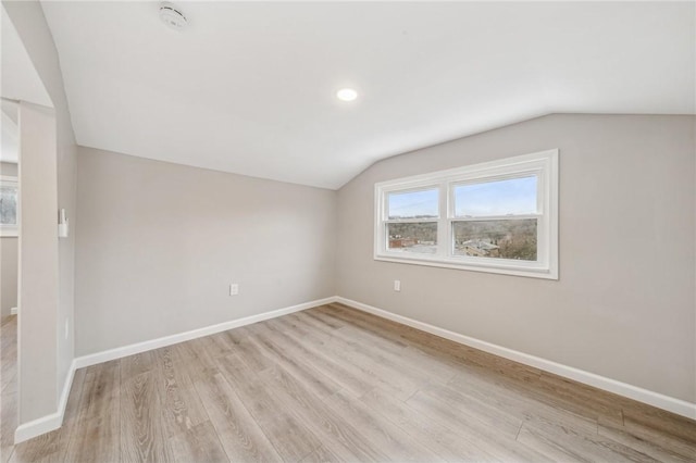 bonus room with lofted ceiling and light wood-type flooring