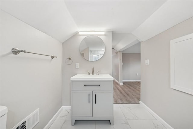 bathroom featuring vaulted ceiling, vanity, and toilet