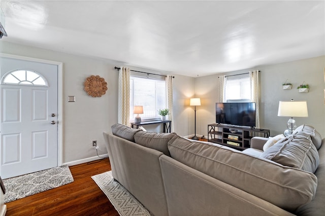 living room featuring dark wood-type flooring and plenty of natural light