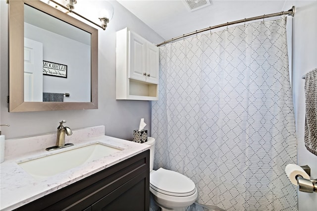 bathroom featuring vanity, walk in shower, and toilet