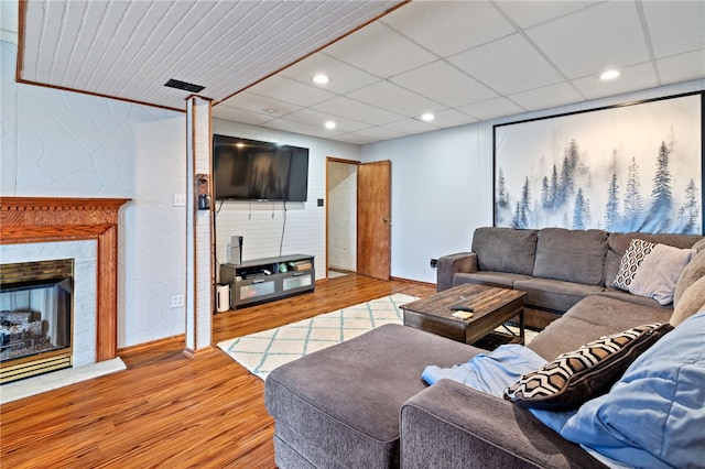 living room with light hardwood / wood-style flooring and a paneled ceiling