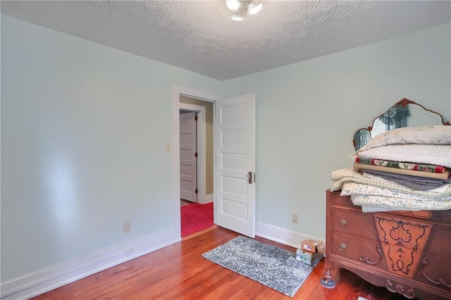 bedroom with light hardwood / wood-style floors and a textured ceiling