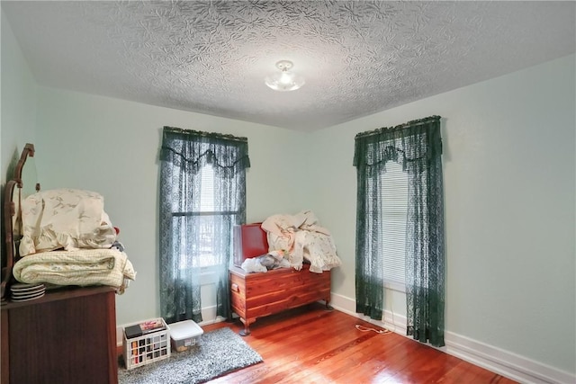 bedroom featuring hardwood / wood-style flooring and a textured ceiling