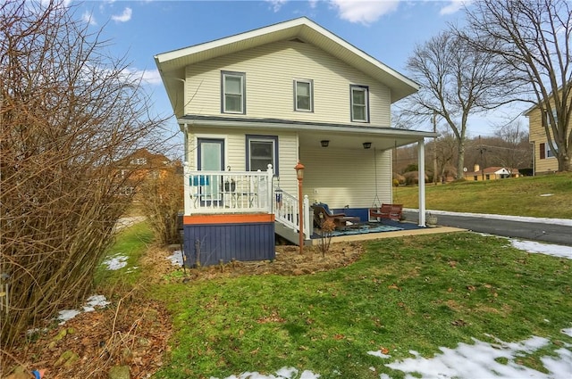 rear view of property featuring a lawn