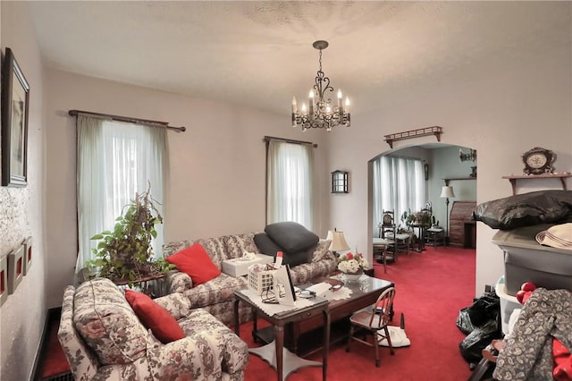 carpeted living room with plenty of natural light and a chandelier