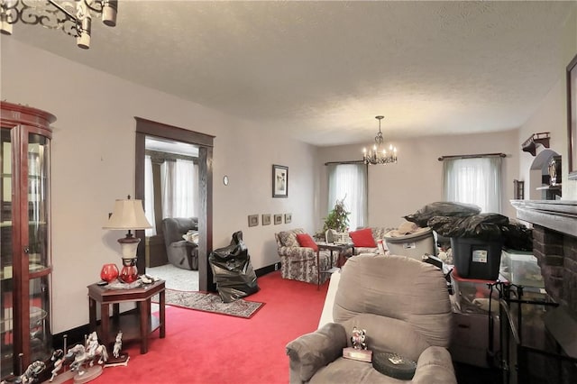 carpeted living room featuring a notable chandelier, a textured ceiling, and a healthy amount of sunlight