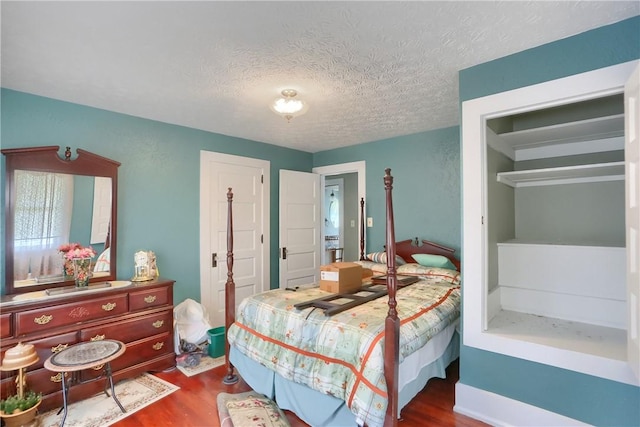 bedroom with dark wood-type flooring and a textured ceiling