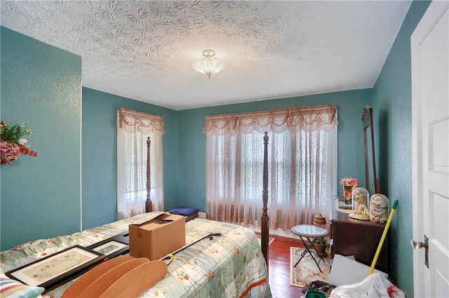 bedroom with wood-type flooring and a textured ceiling