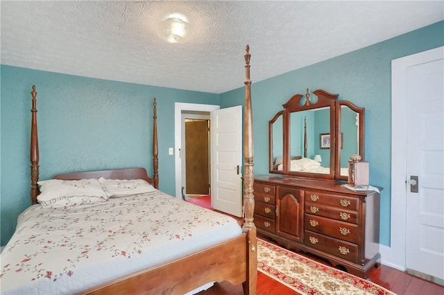 bedroom featuring hardwood / wood-style floors and a textured ceiling