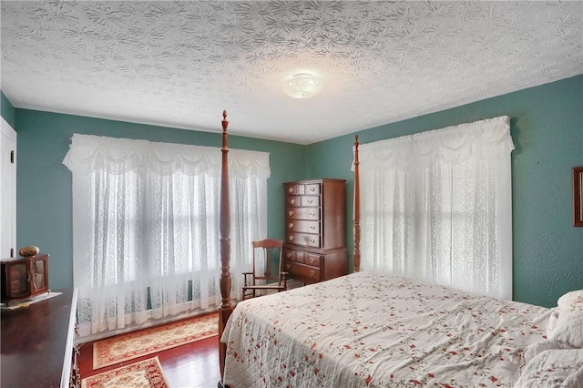 bedroom featuring hardwood / wood-style floors and a textured ceiling