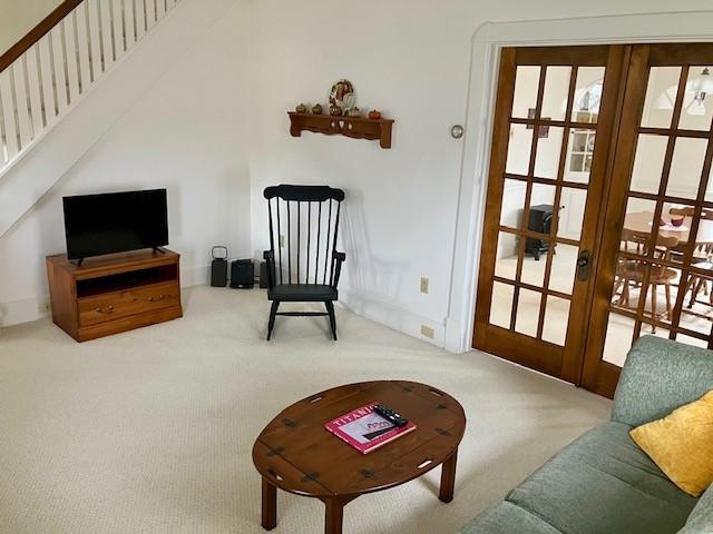 living area with french doors and carpet