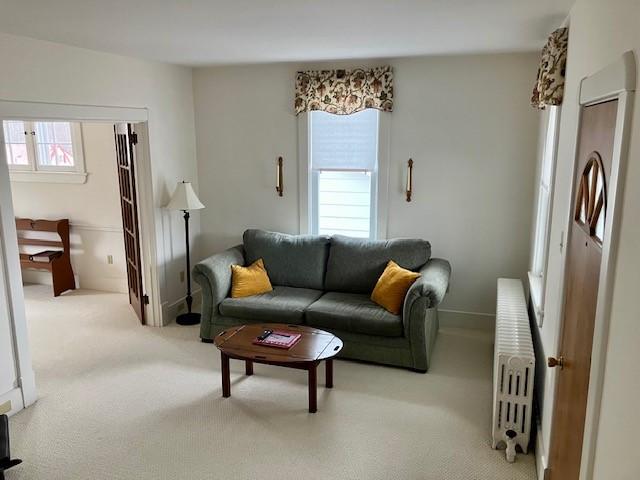 carpeted living room with radiator heating unit