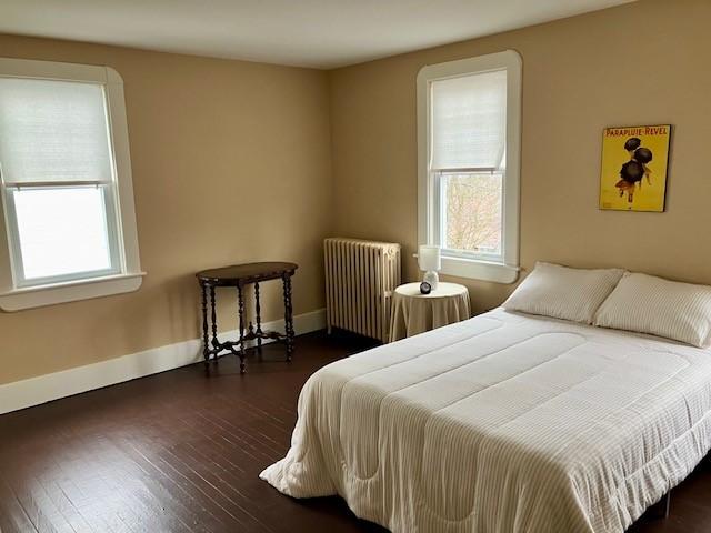 bedroom featuring radiator and dark hardwood / wood-style floors