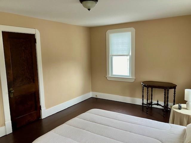 bedroom with dark wood-type flooring