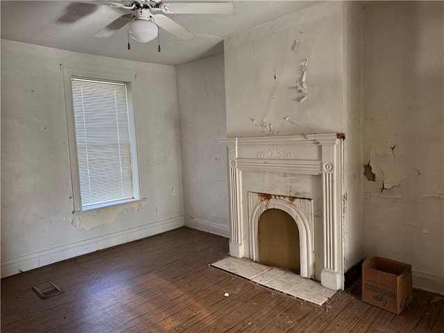 unfurnished living room with ceiling fan and wood-type flooring